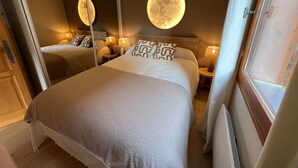 Ett hotellrum med två sängar, en stor spegel och en rund väggdekoration.