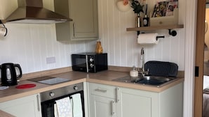 Eine kleine Küche mit Backofen, Toaster und Spüle.
