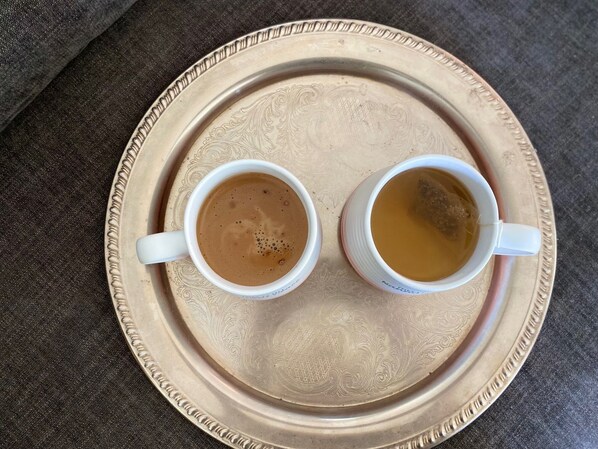 Dos tazas de café sobre una bandeja con diseños elaborados.