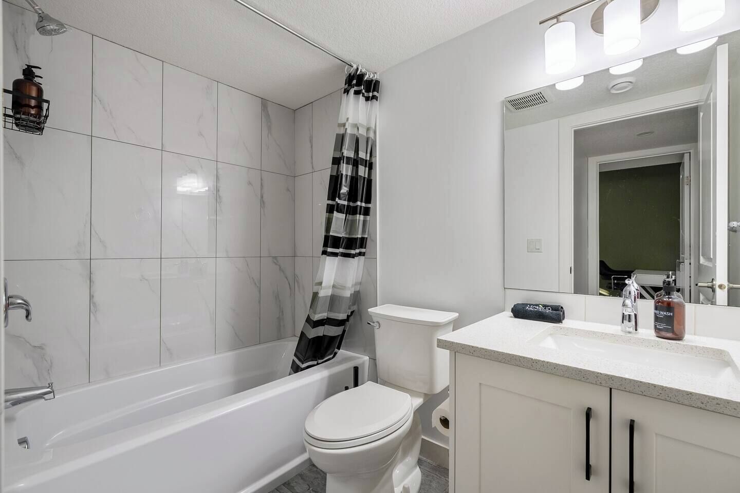 A bathroom with a bathtub, toilet, and sink.
