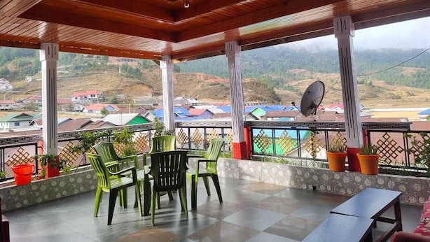 A covered outdoor seating area with a view of a village.