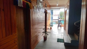 A hallway with wooden walls, a potted plant, and a staircase.