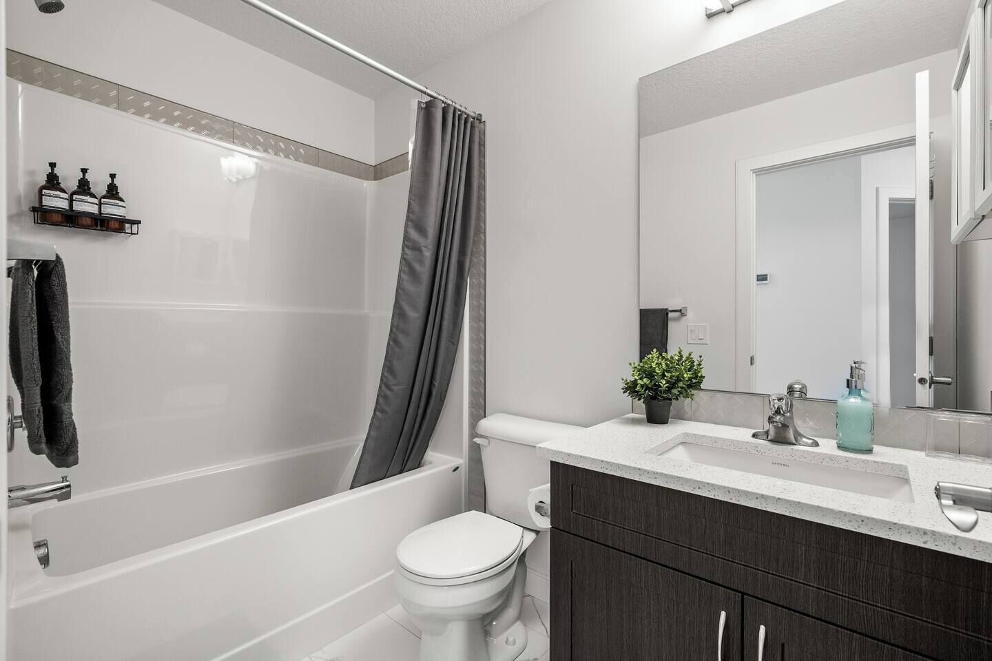 Une salle de bain moderne équipée d’une baignoire, de toilettes et d’un meuble-lavabo.