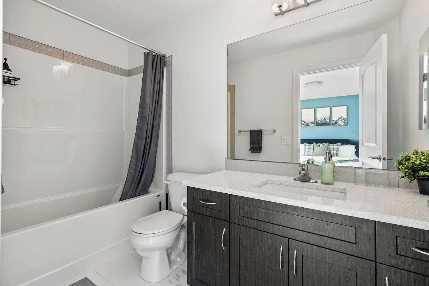A modern bathroom with a shower, toilet, and vanity.