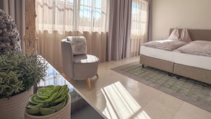 Une chambre à coucher moderne avec un lit, une chaise, une lampe et une plante en pot.