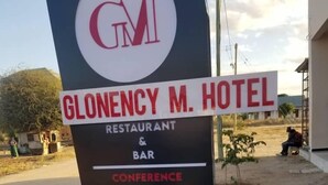 Señal de Glonency M. Hotel anunciando restaurante, bar, alojamiento para conferencias y Wi-Fi gratuito.