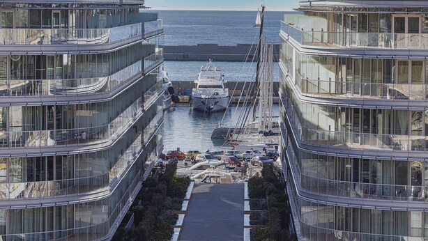 A modern building with multiple balconies overlooking a marina with boats. - Waterfront Vibes by Wonderful Italy (Genoa)