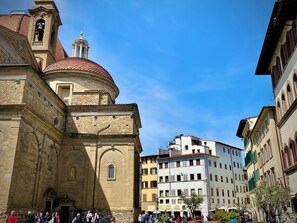A historic building with a dome and bell tower, surrounded by modern buildings and a busy street. - Chic Stay Boutique Apartments (Florence)