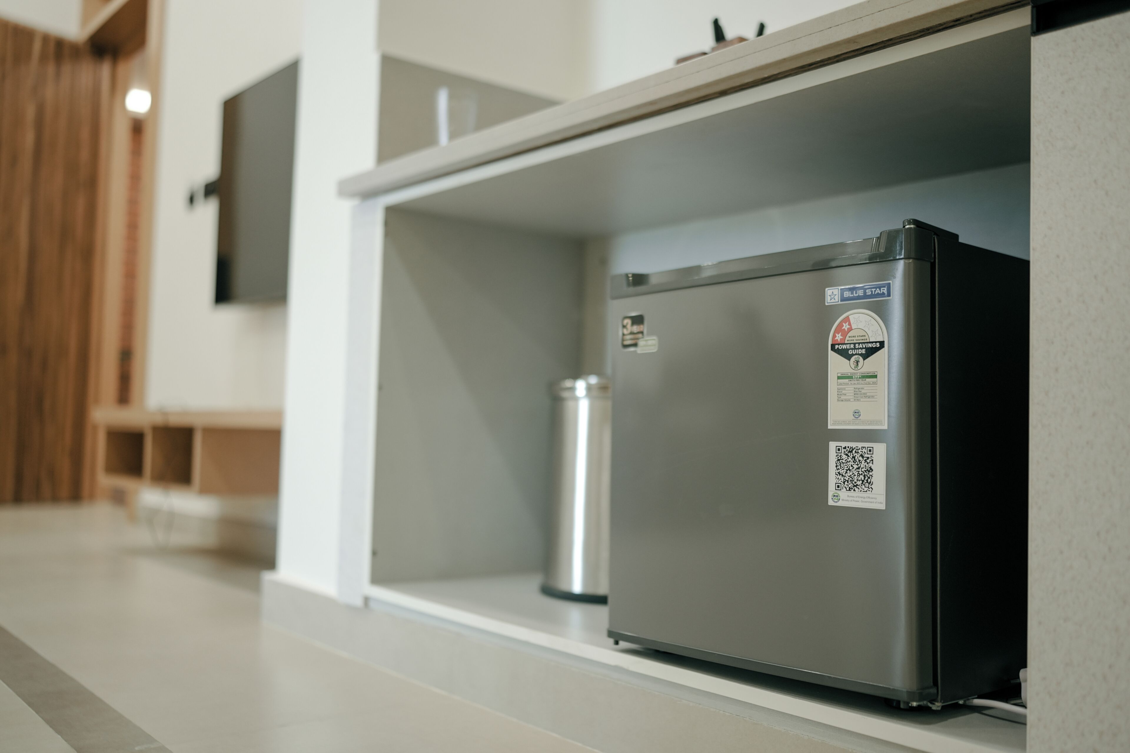 Eine moderne Küche mit einem Edelstahlkühlschrank, einem Wasserspender aus Metall und einer weißen Arbeitsplatte.
