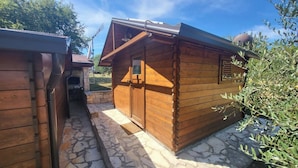 A wooden cabin with a stone foundation, a metal roof, and a small window. - Casa Robinson Nature Wifi Istria Croazia (Vizinada)