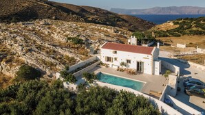A white villa with a red-tiled roof, a swimming pool, and a view of the sea and hills. - Villa Froudi (Kissamos)