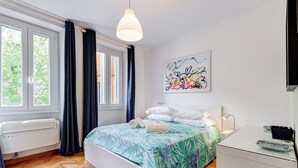 A modern bedroom with a bed, a desk, and a window with curtains. - Luminous Apartment few steps P.za Navona (Rome)