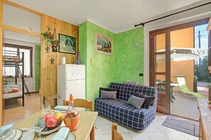 Departamento familiar, varias habitaciones (Holiday Sun Puegnago | Terrace & Pool) | Área de sala de estar | Televisión de pantalla plana