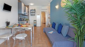 Una cucina moderna con zona pranzo, divano e una pianta grande.