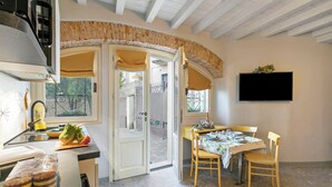 Une cuisine équipée d’une cuisinière, d’un évier et d’un coin repas avec une table et des chaises.