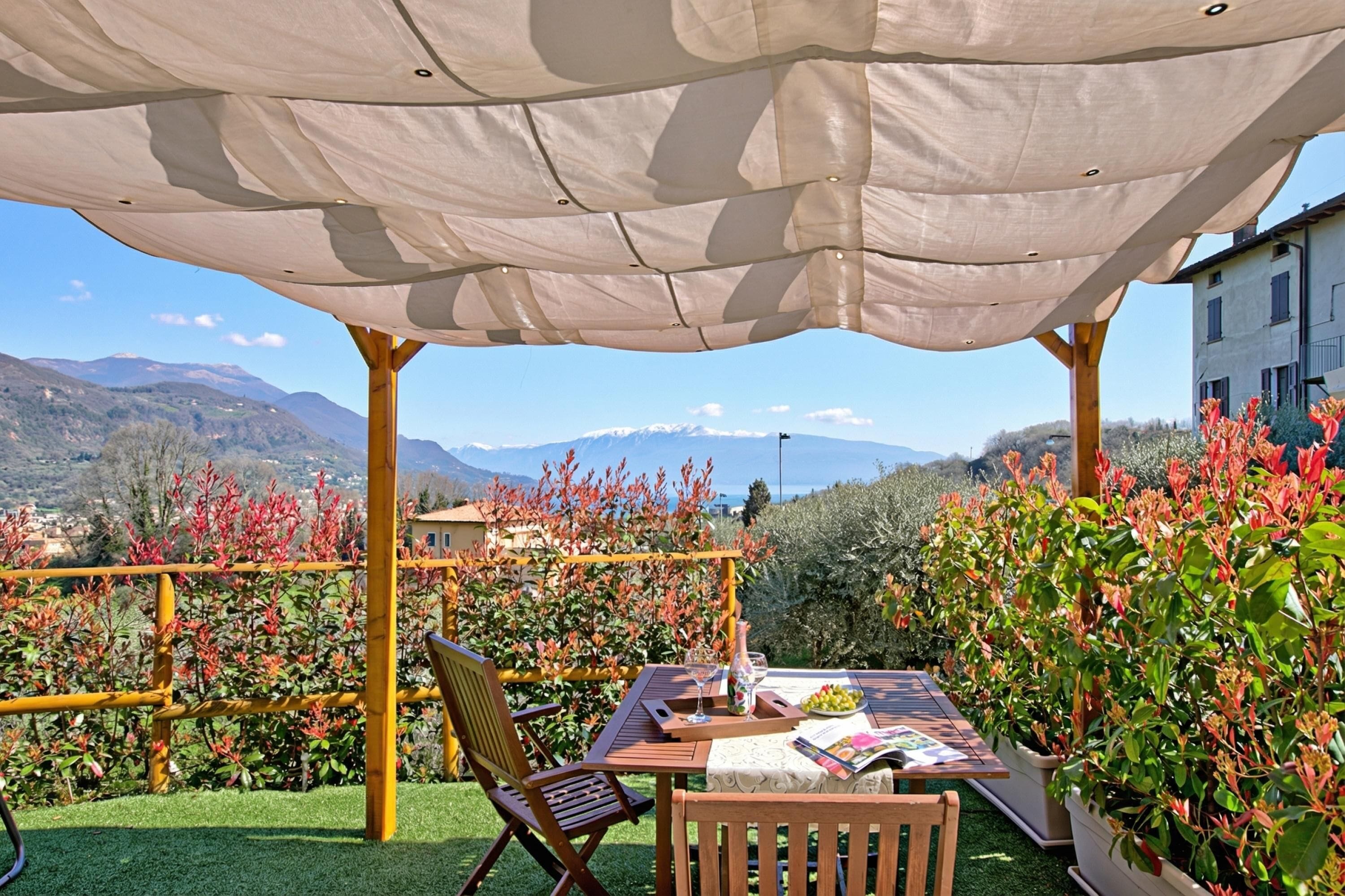 Un área de estar al aire libre con una mesa, sillas y un mantel.