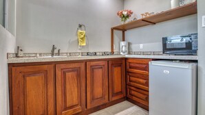 Eine Küche mit Holzschränken, einem Edelstahlkühlschrank, einer Mikrowelle und einer Kaffeemaschine.