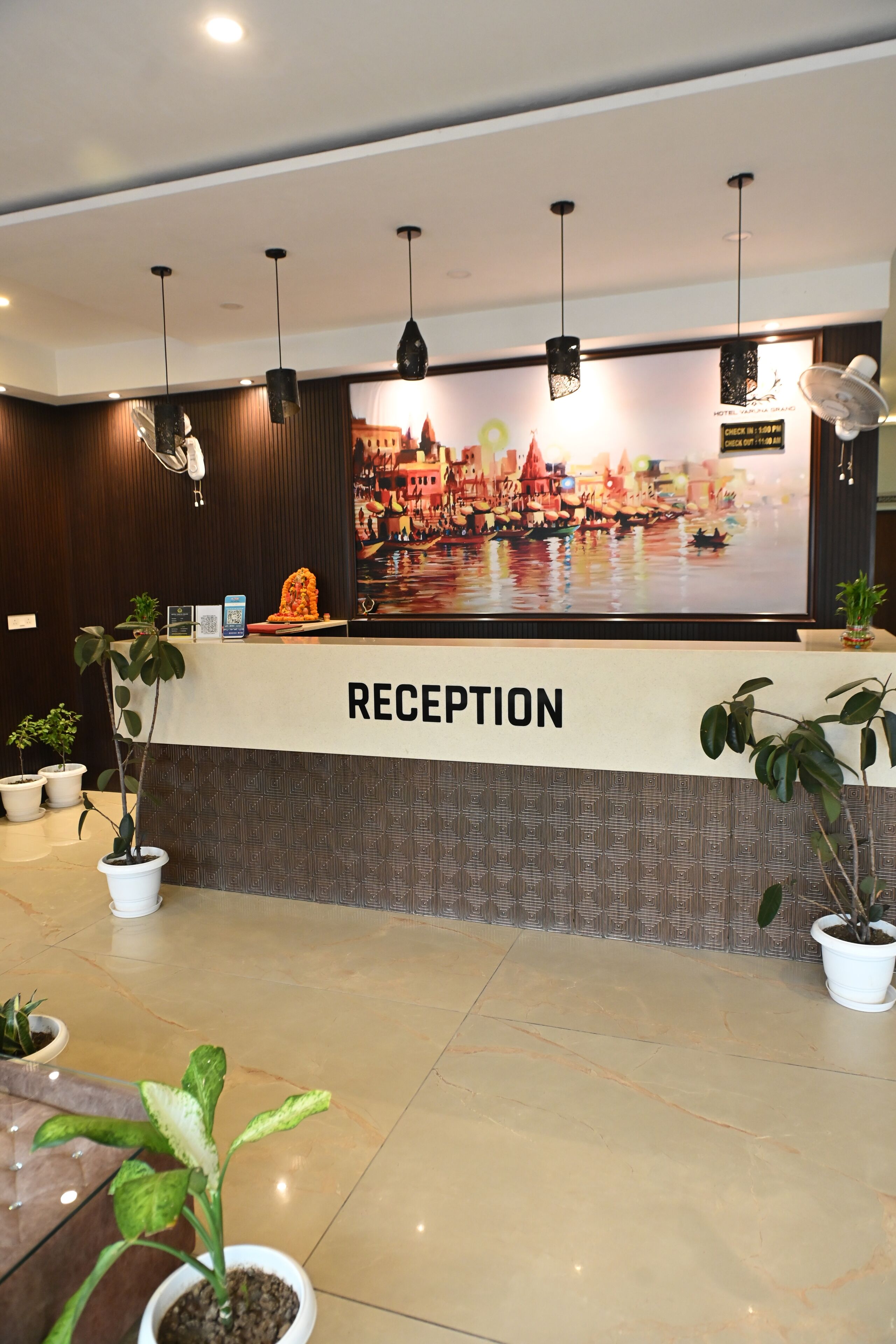A reception area with a 'RECEPTION' sign, potted plants, and a large decorative wall.