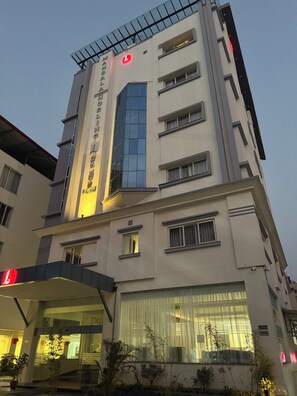 MANDALA HOTEL features a modern architectural design with a glass and solid facade.