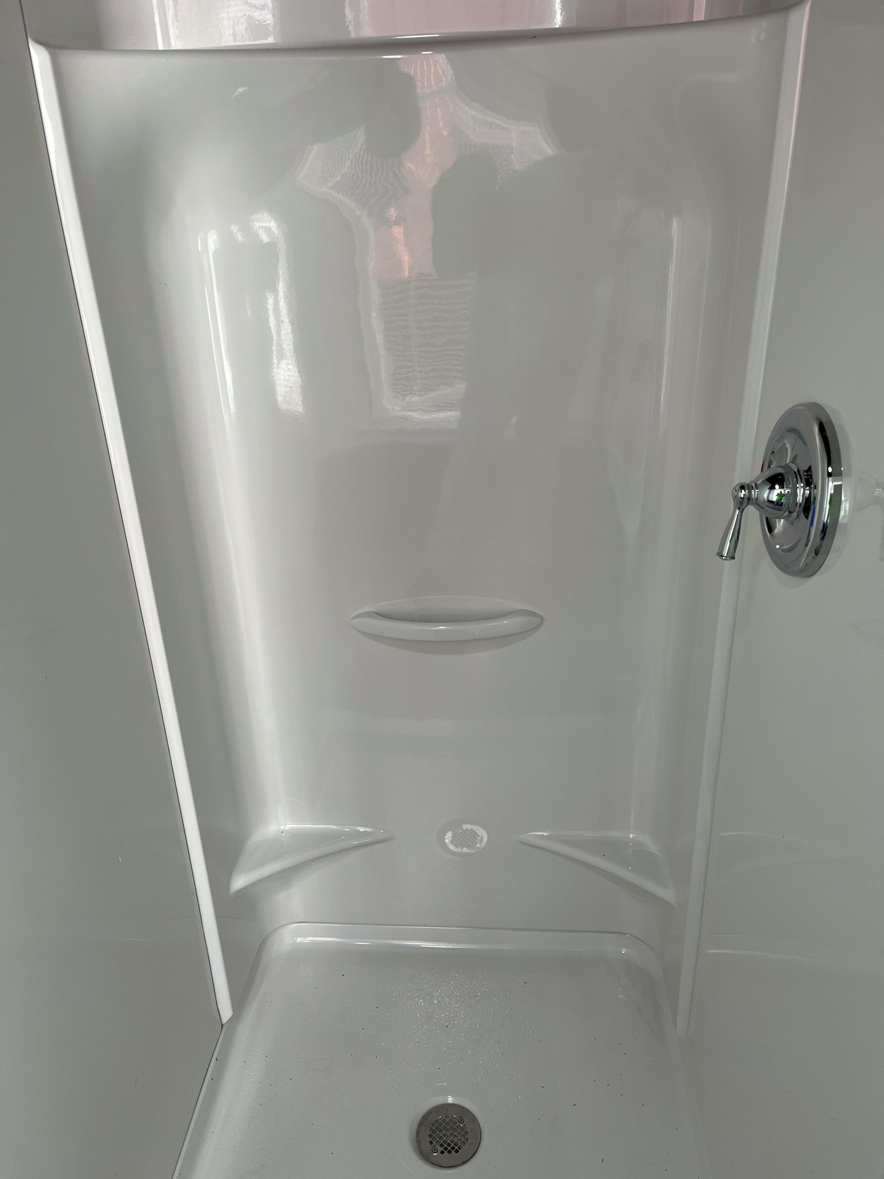 Een douche, handdoeken, zeep, toiletpapier