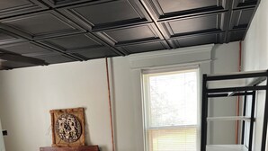 A bedroom with a bed, dresser, window, and built-in shelving unit.