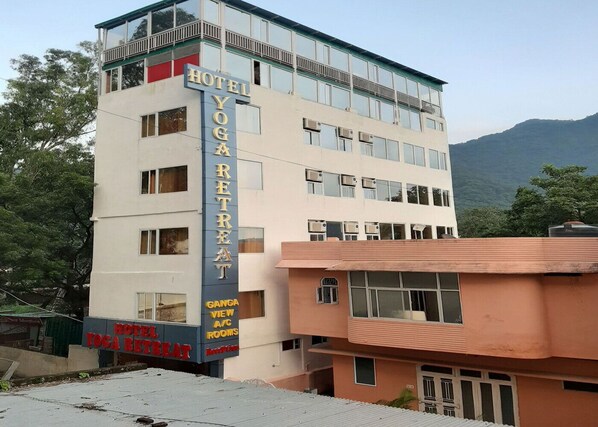 A multi-story building with a sign indicating it is a hotel and yoga retreat.