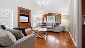 Ein Wohnzimmer mit Fernseher, Sofa, Couchtisch und Kamin.