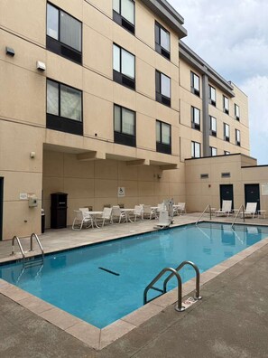 A swimming pool with lounge chairs and a building with multiple windows. - Surface Boutique Hotel, Will Rogers Airport, Fairgrounds, Restaurant & Bar (Oklahoma City)