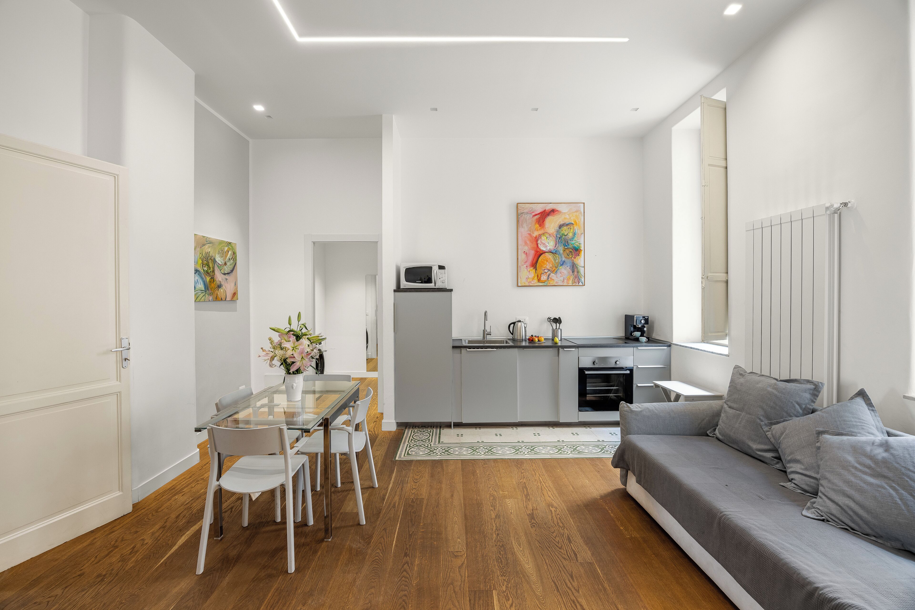 A modern apartment with a dining area, kitchen, and living room.