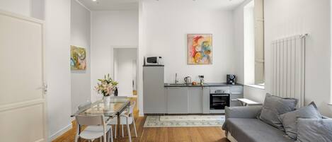A modern apartment with a dining area, kitchen, and living room.