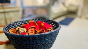 A blue woven bowl filled with dried flowers and leaves on a table. - Hôtel Restaurant Le Cavalier (Soyhières)