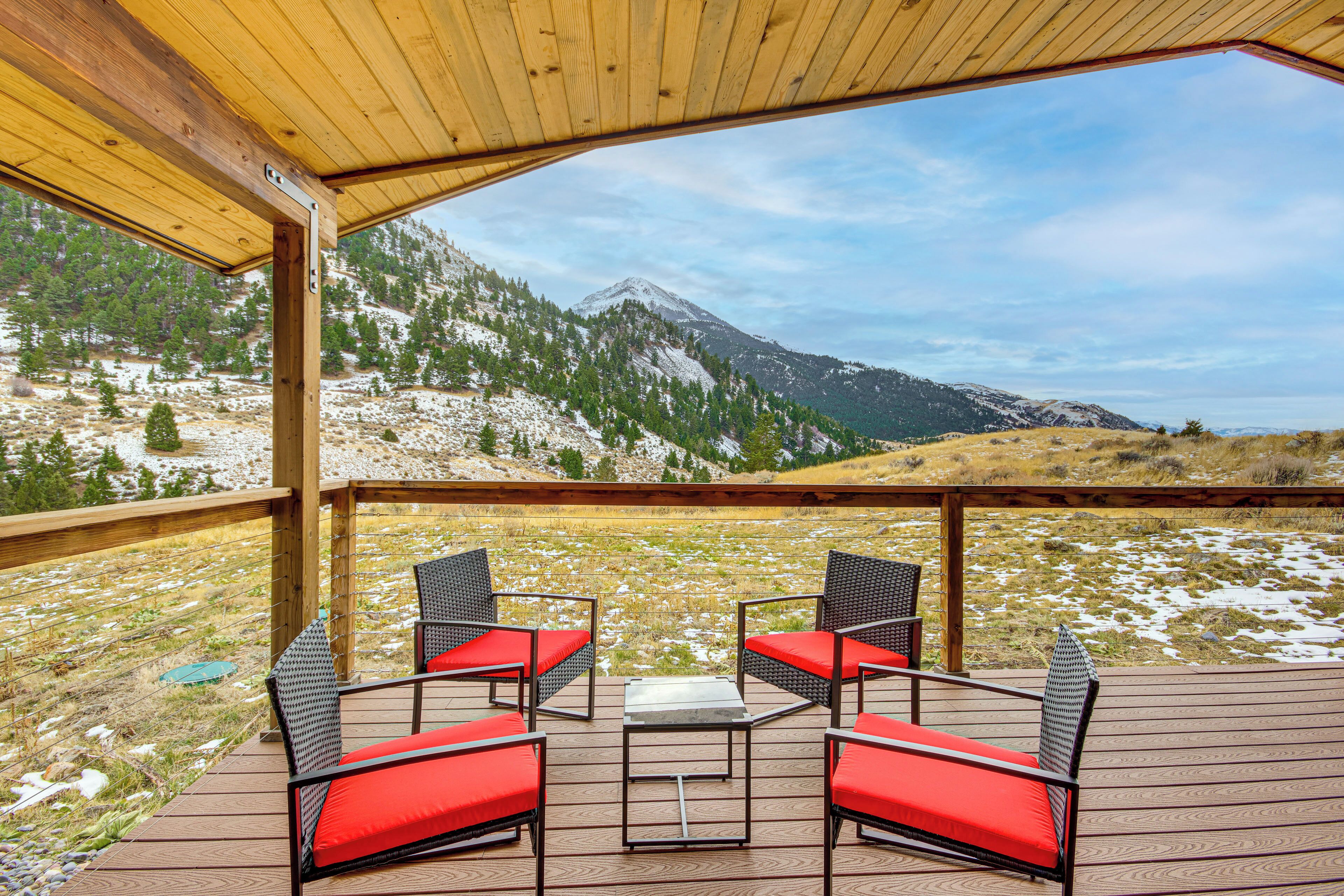 Une terrasse en bois avec des sièges extérieurs et une vue sur la montagne.