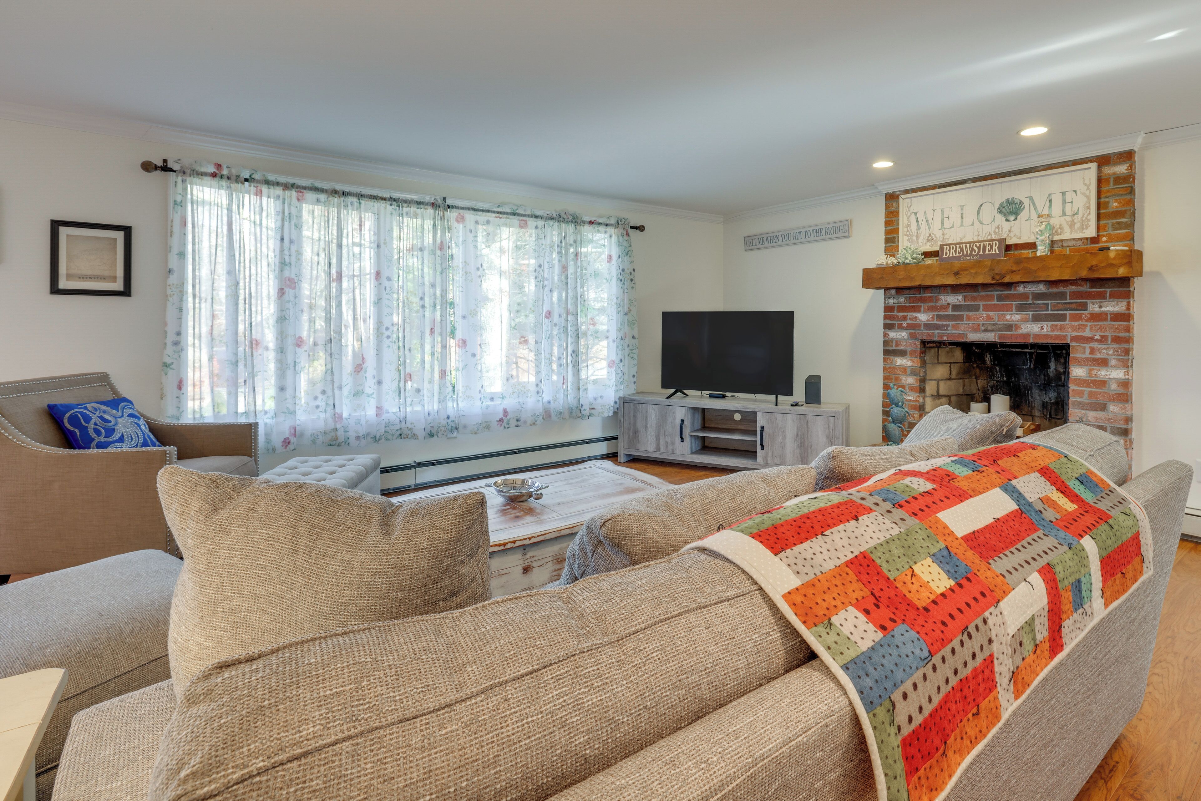 A living room with a sofa, a coffee table, a TV, and a fireplace.