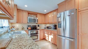A modern kitchen with wooden cabinets, stainless steel appliances, and a granite countertop. - 6 Mi to Beach: Home w/ Deck in Brewster! (Brewster)