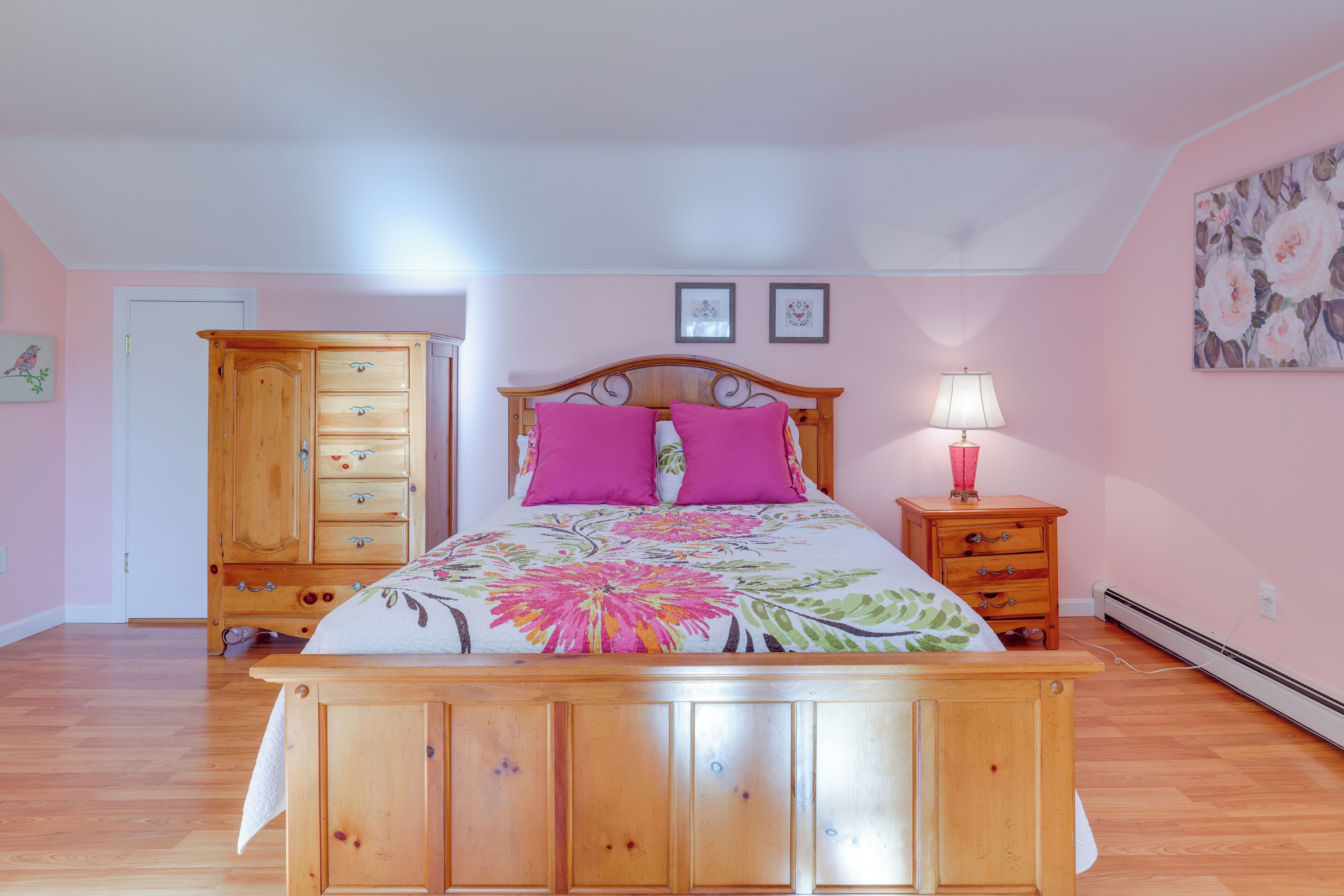 Une chambre à coucher avec un lit en bois, une table de chevet, une commode et une porte.