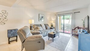 Uma sala de estar moderna com sofá, poltrona, mesa de centro e um rack para TV.