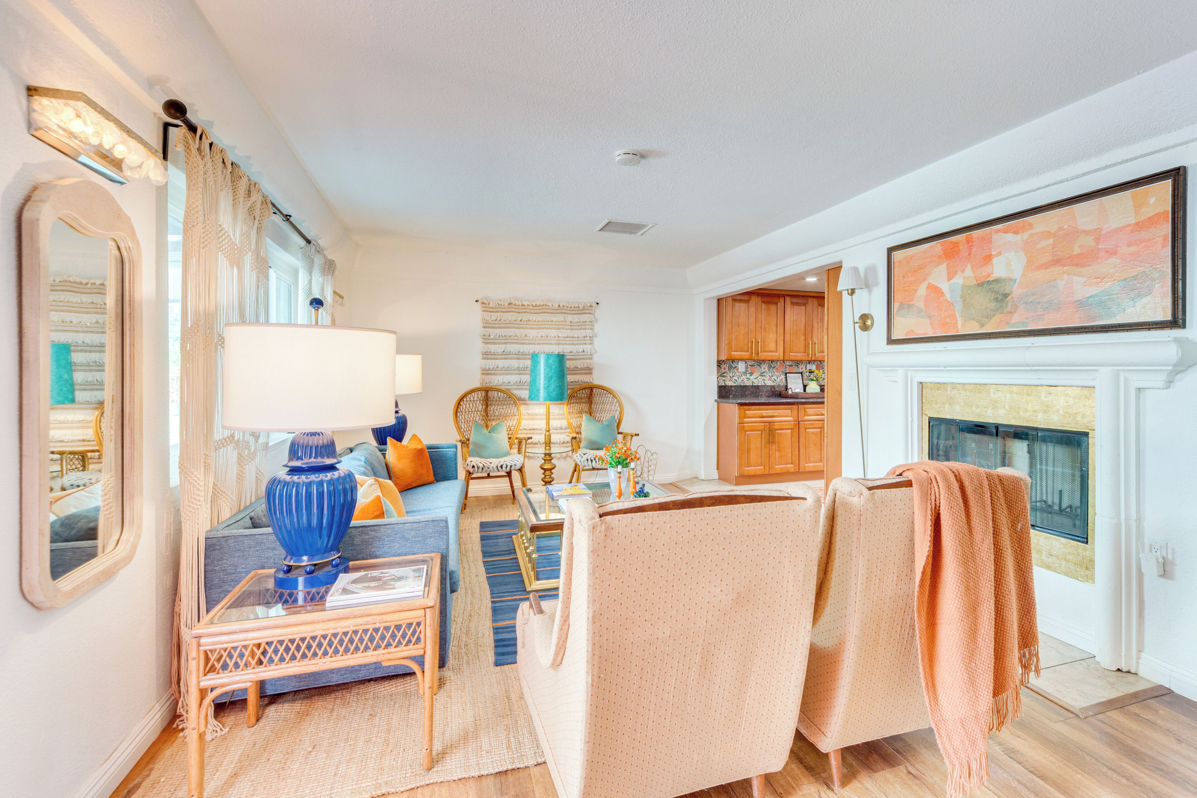 A spacious living room with a sofa, armchairs, a coffee table, and a fireplace.