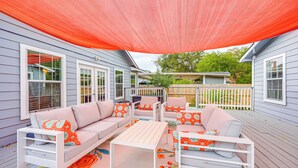 An outdoor patio with a white sofa set, a table, and a large orange shade sail. - 3 Mi to Dtwn: Cozy San Antonio Home w/ Casita! (San Antonio)