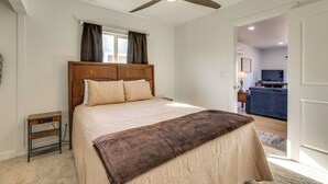 A bedroom with a bed, a ceiling fan, a nightstand, and a view into the living area. - Phoenix Casita 11 Mi to Dtwn, Baseball & More (Phoenix)