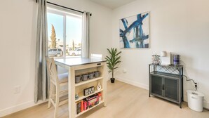 A modern living room with a dining table, a bookshelf, a potted plant, a cabinet, and a painting on the wall. - Phoenix Casita 11 Mi to Dtwn, Baseball & More (Phoenix)