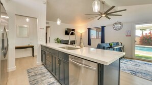 A modern kitchen with a central island, stainless steel appliances, pendant lighting, and a ceiling fan. - 11 Mi to Dtwn Phoenix: Main House w/ Outdoor Oasis (Phoenix)