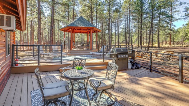 A wooden deck with outdoor furniture, a gazebo, and a grill area surrounded by tall pine trees. - Gazebo w/ View & EV Charger: Rustic Williams Cabin (Williams)
