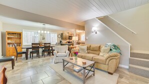 A living room with a sofa, coffee table, and dining area.