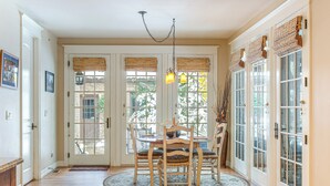 A dining area with a round table, chairs, and a chandelier. There are two doors with windows and a view of the outside. - Walk to DU, Dining & Parks: Spacious Denver Home! (Denver)