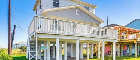A two-story house with a covered porch and a balcony.