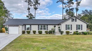 A two-story house with a garage, a front lawn, and a driveway. - Near Fort Liberty: Home w/ Yard in Fayetteville! (Fayetteville)