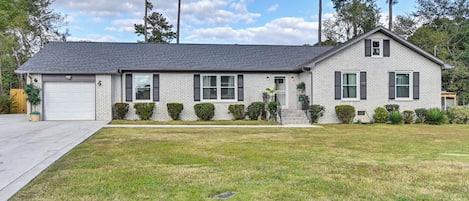 A two-story house with a garage, a front lawn, and a driveway.