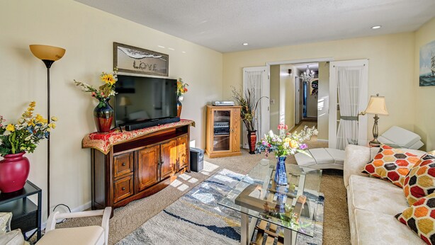 A living room with a television, wooden cabinet, sofa, and a glass coffee table. - Near Fort Liberty: Home w/ Yard in Fayetteville! (Fayetteville)