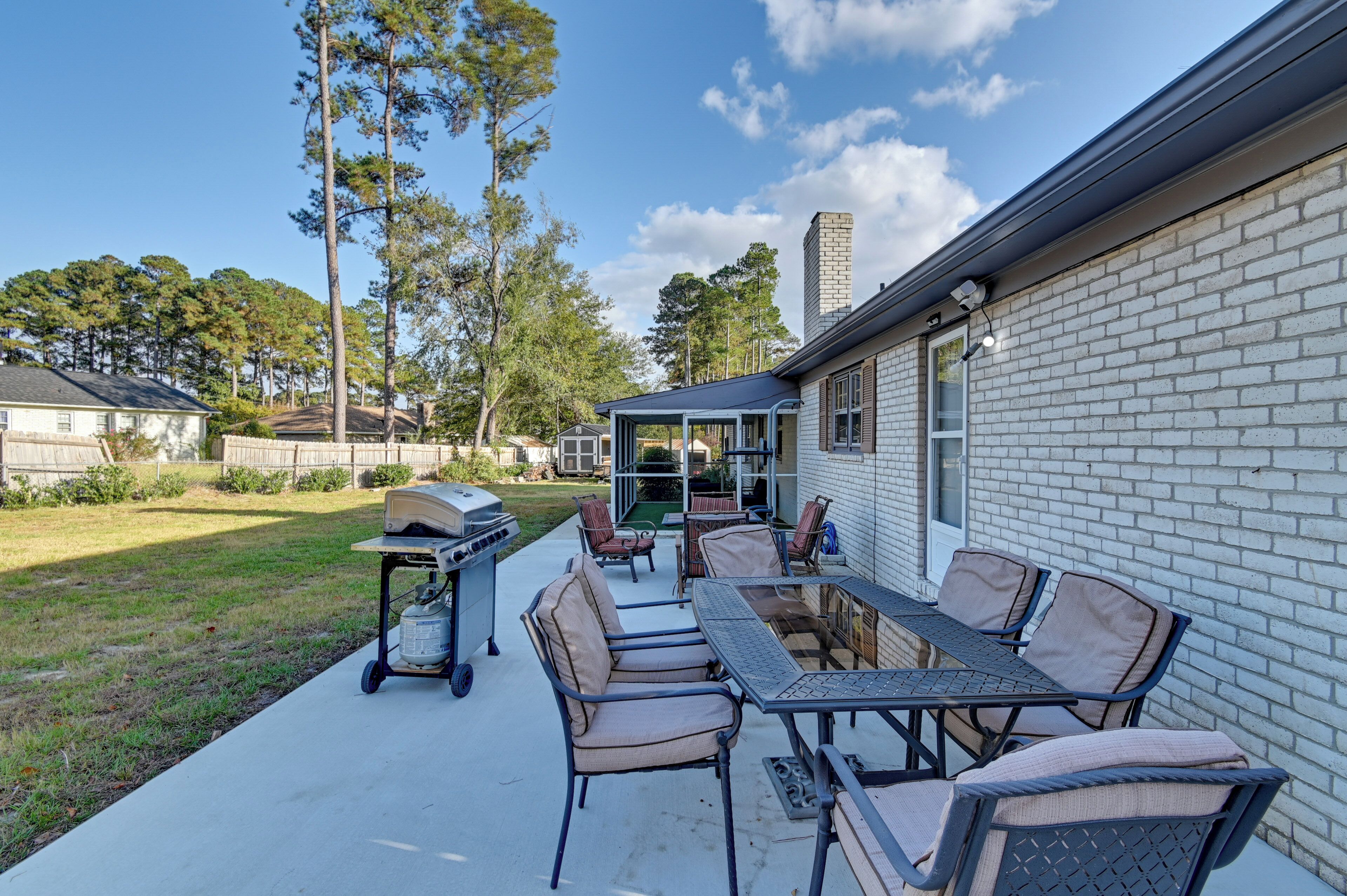 A patio with a grill, outdoor seating, and a covered area.
