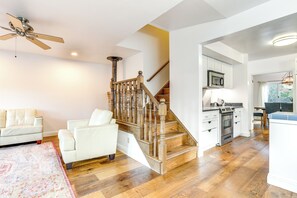 A spacious living area with a wooden staircase, a white sofa, and a kitchen with modern appliances. - 12 Mi to Folsom Historic District: Norcal Getaway (Sacramento)